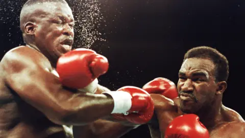 Evander Holyfield lands a right hand on Buster Douglas