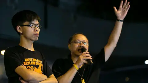 Getty Images  Student leader Joshua Wong (L) listens as Occupy Central leader Benny Tai speaks during the evening session at a pro-democracy protest site outside the central government offices in Hong Kong October 19, 2014 in Hong Kong.