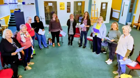 Ellie Wright Ten members of the singing group 