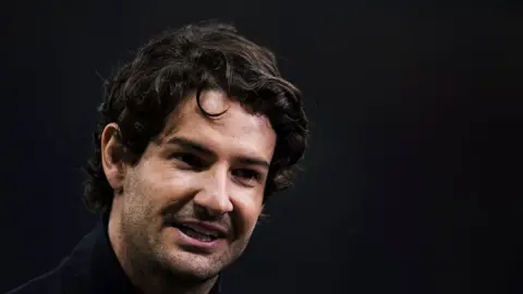 Getty Images Alexandre Pato pictured at a football game is wearing a dark coloured coat. He has stubble and dark, wavy hair.