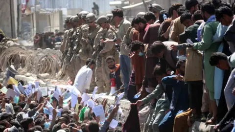 Getty Images Afghanistan berjuang untuk mencapai pasukan asing untuk menunjukkan kredensial mereka untuk melarikan diri dari negara itu di luar Bandara Internasional Hamid Karzai, di Kabul, Afghanistan.