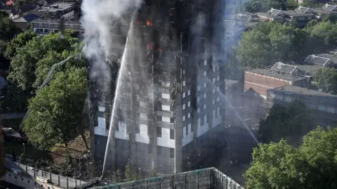 Los bomberos de Getty Images abordan el edificio después de que un gran incendio envolvió el bloque de la Torre Grenfell residencial de 24 pisos en Latimer Road, West London en las primeras horas de esta mañana el 14 de junio de 2017 en Londres