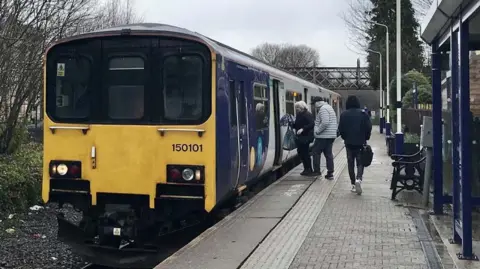 Robbie MacDonald People boarding a train at Brierfield railway station