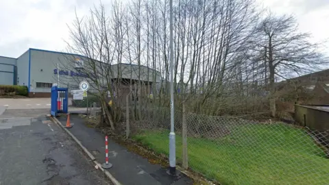 Google Sidhill Business Park in Holmfield. It shows a large industrial-type building  with fencing and trees bordering the site. 