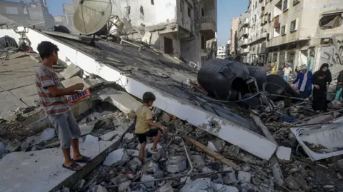 EPA family members inspect the rubble of their old house after an air strike during an Israeli military operation in Gaza City, Gaza Strip, October 3, 2025