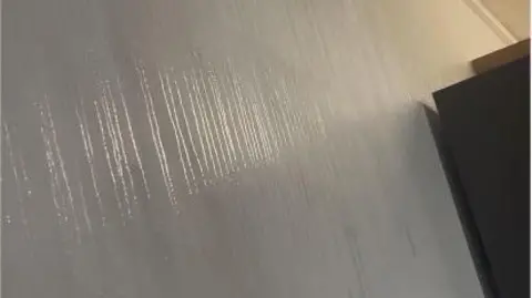 supplied Water dropping down a white wall, with cupboard in rear