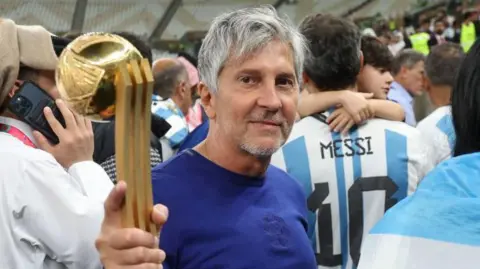 Jorge Messi holding his son Lionel Messi's trophy for best player at the 2022 World Cup after Argentina beat France in the final in Qatar