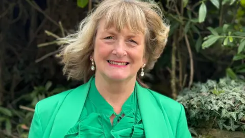 A picture of Ali smiling into camera. 