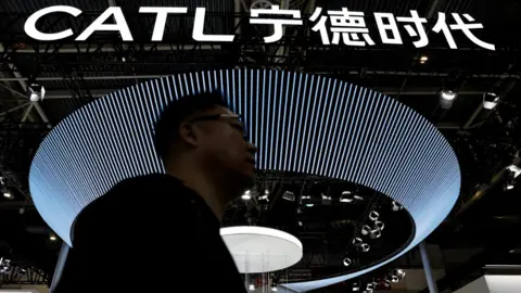 A man walks past the logo of battery manufacturer CATL at its booth at the Beijing International Automotive Exhibition, or Auto China 2024, in Beijing, China on 25 April, 2024. 