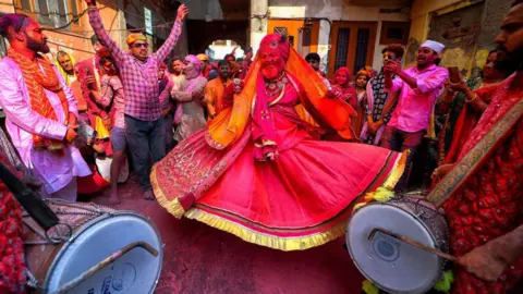 Getty Images Um padre usando pano indiano tradicional visto dançando as batidas do tambor