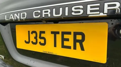 Yellow car number plate reading  'J35 TER' 