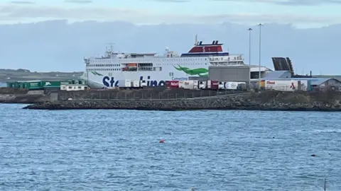 A Stena Line ferry seen near a port. The water is calm in the foreground.