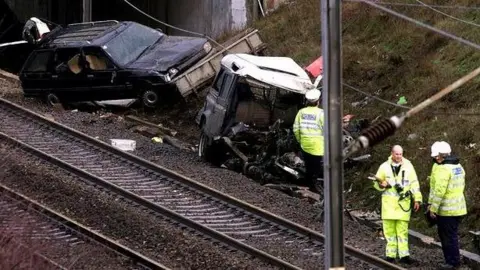 PA Media Image shows wreckage of Gary Hart's Land Rover and trailer by the railway line 