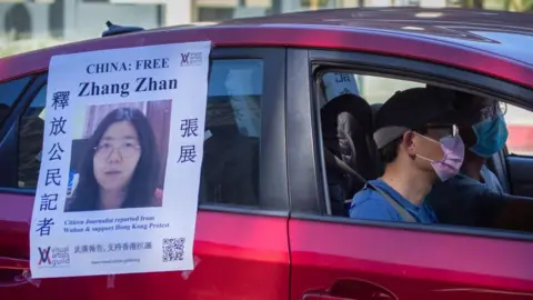 Getty Images A car with a poster calling for the release of Zhang Zhan