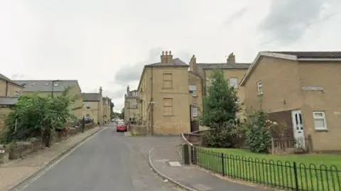 A residential street with clay-coloured houses.