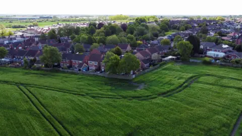 Reuters A drone view showing a large green field and houses - looking towards Ashton-in-Makerfield in Greater Manchester.
