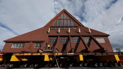 Reuters Kiruna's historic wooden church sits on a wheeled transportation unit before being moved to a new site in Kiruna, Sweden 