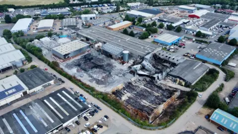 Ant Saddington/BBC An aerial photo of the building gutted by the fire. There are a number of warehouses surrounding it in tact.