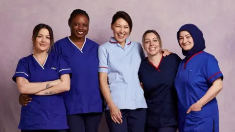 UKTV Emma Willis (pictured centre) with four midwives all in blue uniforms