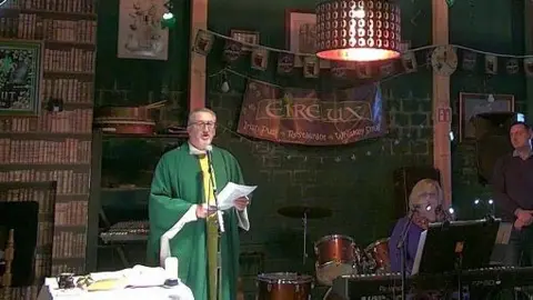 Father Michael Cusack holding mass in Luxembourg pub