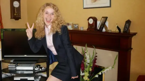 Supplied Picture of Emily Rowling, who has long curly blond hair and is doing a "peace" hand sign to the camera