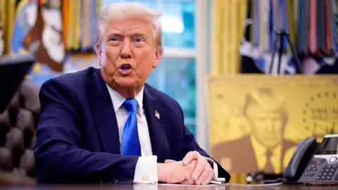Getty Images President Donald Trump takes a question from a reporter before signing an executive order in the Oval Office at the White House establishing the "Trump Gold Card"