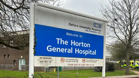 The welcome sign to The Horton General Hospital. There is also a sign pointing to the maternity unit.