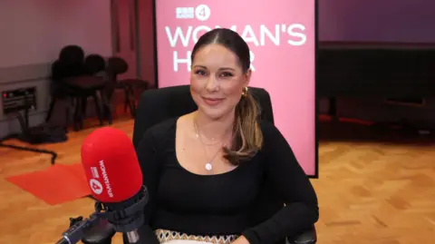 Former Made in Chelsea star, Louise Thompson, sitting in chair with a Woman's Hour banner behind her 