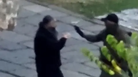 Kosovo government / handout via Reuters An armed man could be seen with a priest inside the Serbian Orthodox monastery in Banjska on Sunday. Photo: September 2023