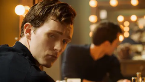 Warren Orchard/Icon Film Distribution Harry as Richard Burton. he looks back over his shoulder past the mirror. His reflection in the mirror behind him