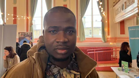 Steve Jones/BBC Abdul Hammed, who has short dark hair and short stubble. He wears a neutral expression and is staring straight at the camera.