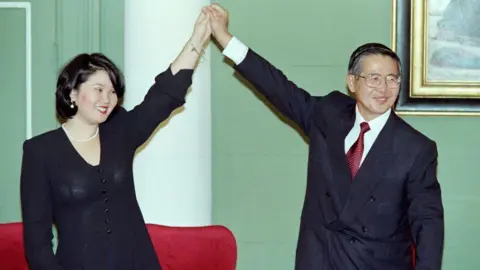 AFP Peruvian President Alberto Fujimori (right) holds up the arm of his eldest daughter Keiko Sofia (left) after receiving his credentials to be sworn in as president for a five-year term on May 12, 1995.