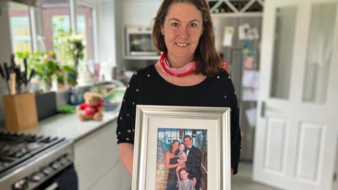 Anna with a photograph of her family