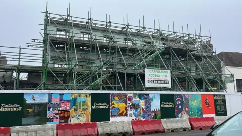 George Carden/BBC Scaffolding covering the front of the 400 year old Angel Inn midhurst which also has a wooden wall around the front