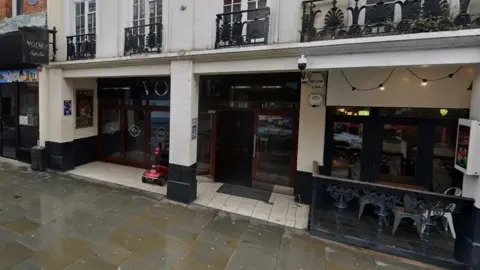 Google A white-fronted building with the entrance set back under the first floor. The letters VO are visible above the doors.