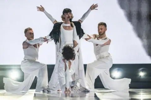 EPA-EFE/Shutterstock Czech Republic's Adonxs performs as part of preparations for Eurovision 2025, four men dressed in white airy clothing carrying out a staged pose.