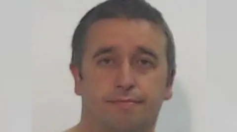 Police Scotland A police mugshot of a round-faced man with short brown hair