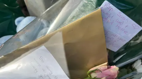 A close up of some of the handwritten tributes, teddies and flowers laid near the police cordon. One of the notes reads: RIP Sarah – beautiful, kind and wonderful mother.