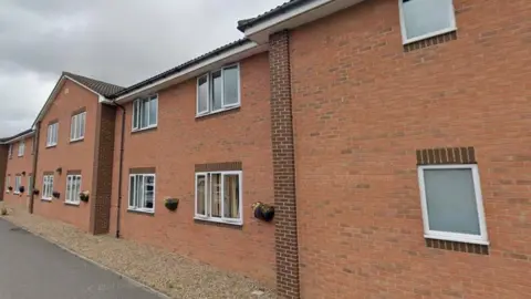 Google The outside of recently built care home. The two-storey building features lots of windows and flower boxes.