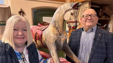 Paddy and Samantha Cree posing for a photo with the old rocking horse.