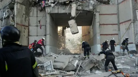 Eugene Hertnier/Suspilne Ukraine/JSC Rescue workers conduct search and rescue operations at a high-rise apartment building partially destroyed by Russian shelling on September 24, 2024 in Kharkiv, Ukraine