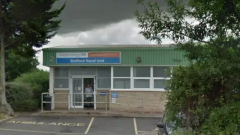 GOOGLE Bedford Renal Unit, a single storey light brick building with green metal cladding, where dialysis patients go for treatment on Napier Road