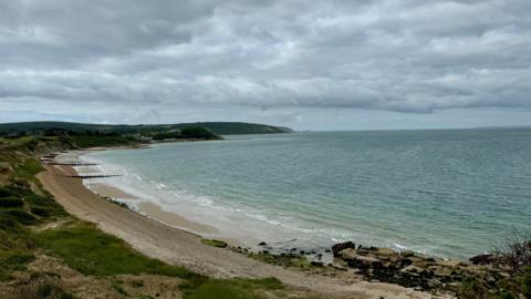Totland Bay on the Isle of Wight being overlooked by dark grey clouds