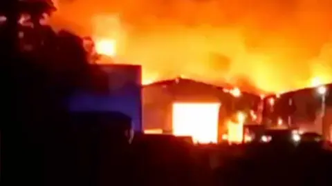 Fire at warehouse filmed at night
