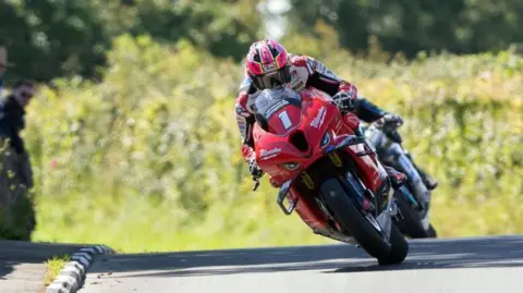 Davey Todd racing on a red bike with he number one on the front.