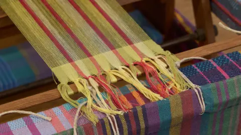 David Rowan Multi-coloured yarn on a loom