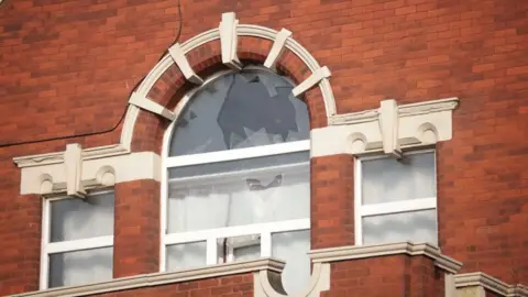  James Speakman/PA Wire Broken window at mosque