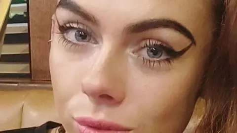 Devon and Cornwall Police Holly Collinson wears flicked eye liner around her blue eyes as she looks directly at the camera 