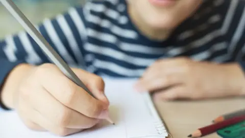 Getty Images Child writing in a note pad