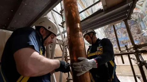 Reuters Image shows workers installing a chimney pipe at the Sistine Chapel, ahead of the conclave, at the Vatican, on 2 May